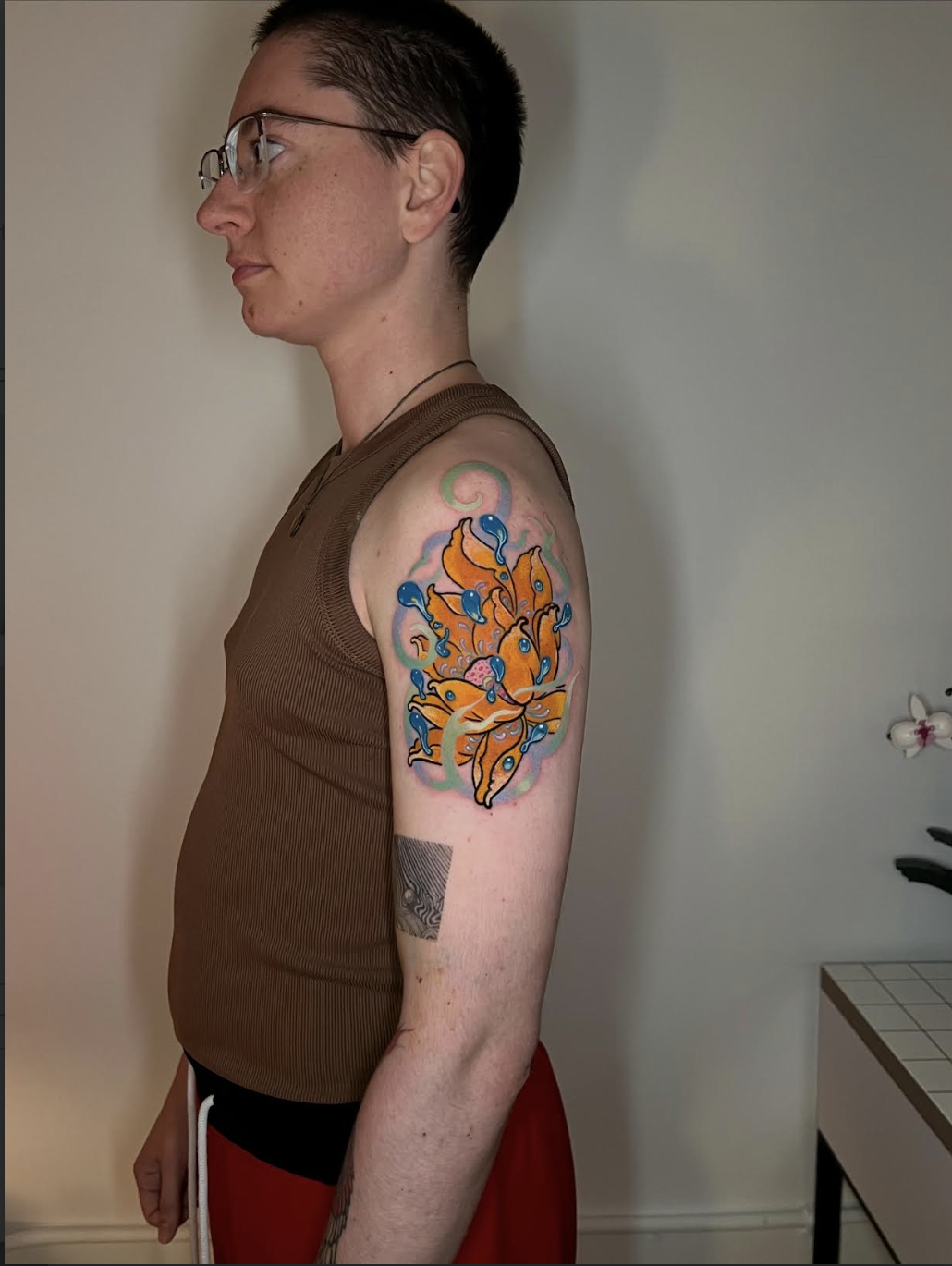 Saturated lotus tattoo with layered color on an upper arm