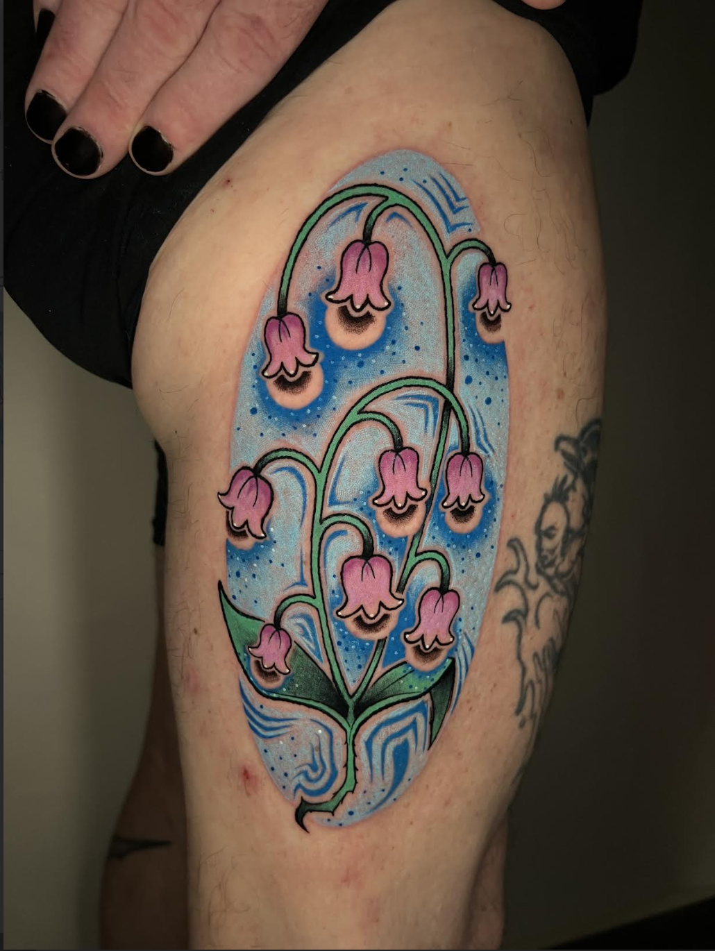 Large color floral thigh tattoo with a blue background