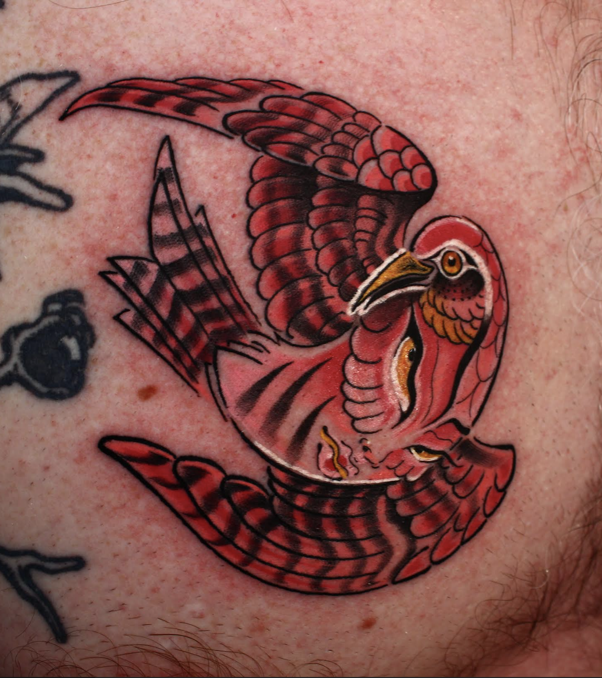 Bright red bird tattoo with layered feather shading