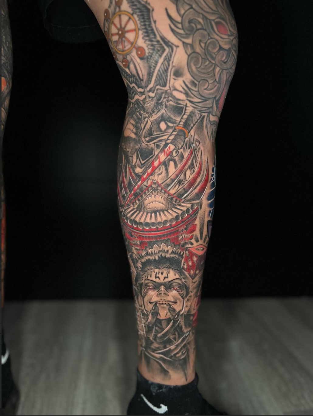 Anime leg sleeve tattoo with blue energy effects and red armor