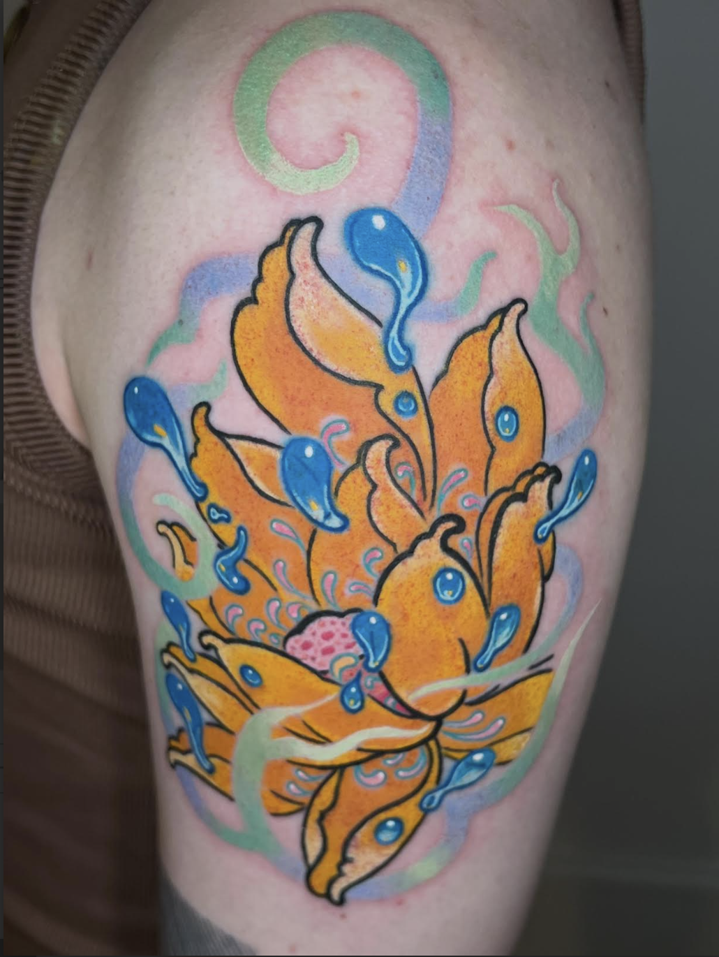 Yellow and orange lotus flower tattoo with soft colour blends